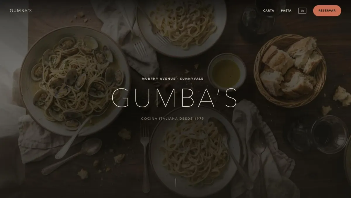 Portada del sitio de Gumba's: fotografia cenital de pasta sobre mesa de madera con el nombre del restaurante encima